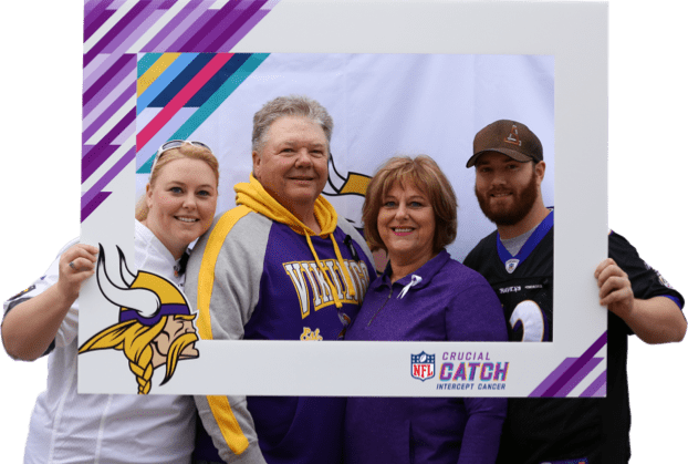 Four people wearing NFL team gear posing in a photo frame for Crucial Catch